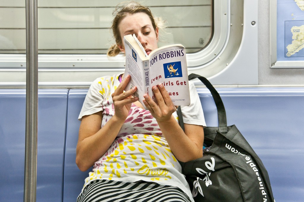 Она читает в метро. Чтение книг в транспорте. Чтение в метро. Девушка в метро с книгой. Человек с книгой в транспорте.